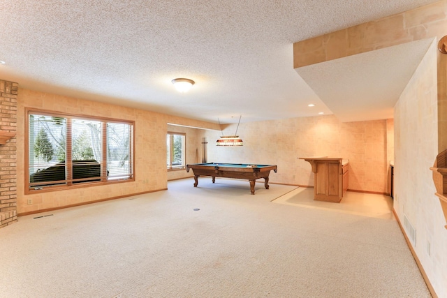 rec room with light carpet and a textured ceiling