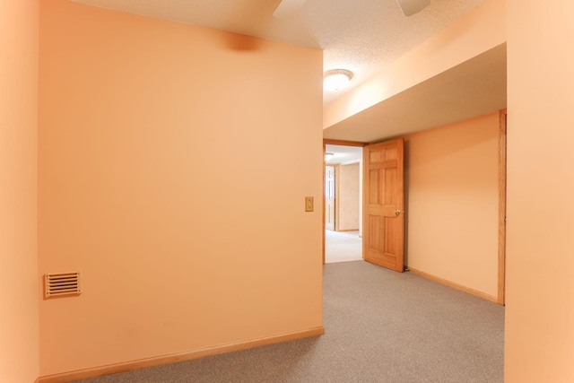 carpeted empty room with a textured ceiling