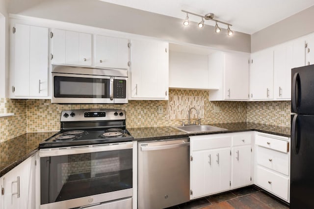 kitchen with appliances with stainless steel finishes, sink, and white cabinets