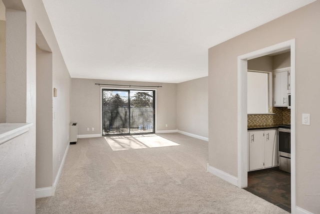 carpeted spare room with radiator heating unit