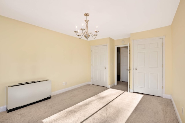 unfurnished bedroom with light carpet and a chandelier