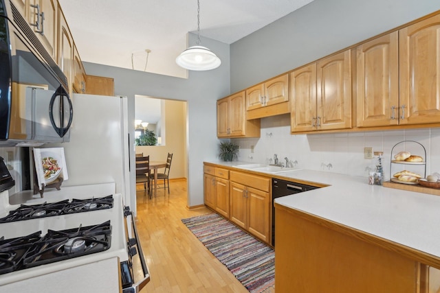 kitchen with pendant lighting, sink, backsplash, black appliances, and light hardwood / wood-style flooring