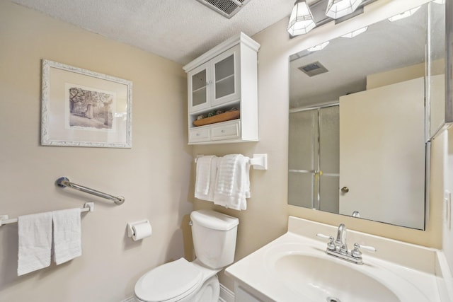 bathroom with vanity, an enclosed shower, a textured ceiling, and toilet