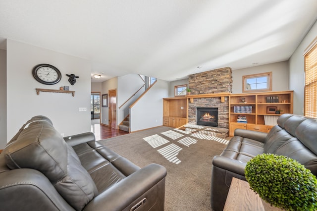 carpeted living room featuring a stone fireplace