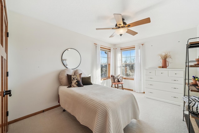 bedroom with light carpet, ceiling fan, and baseboards