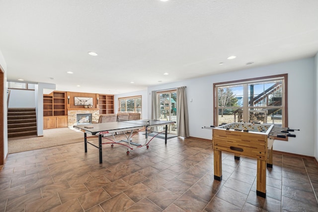 playroom featuring a fireplace, baseboards, built in features, and recessed lighting