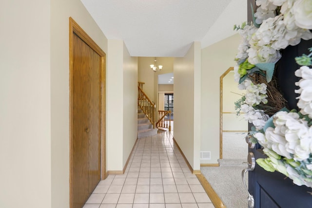 5639 Park Place Dr, Shoreview, MN 55126 - corridor featuring a chandelier, light tile patterned flooring, stairs, baseboards, and light colored carpet