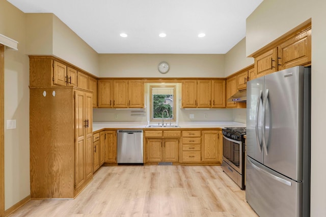 5639 Park Place Dr, Shoreview, MN 55126 - kitchen with stainless steel appliances, a sink, under cabinet range hood, light countertops, and light wood finished floors