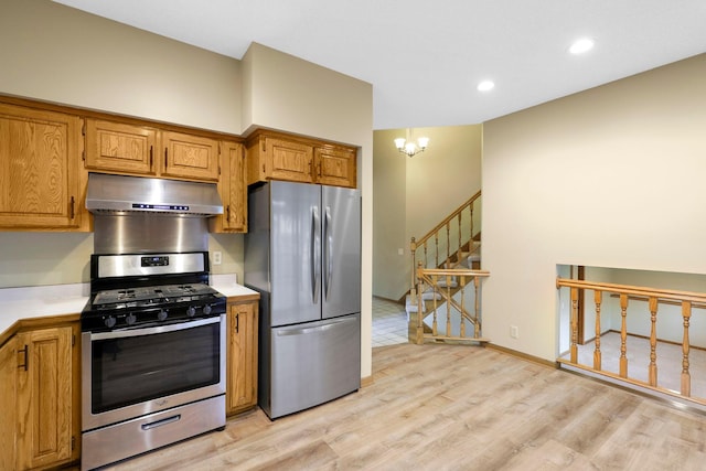 5639 Park Place Dr, Shoreview, MN 55126 - kitchen with under cabinet range hood, appliances with stainless steel finishes, light countertops, light wood-style flooring, and brown cabinetry
