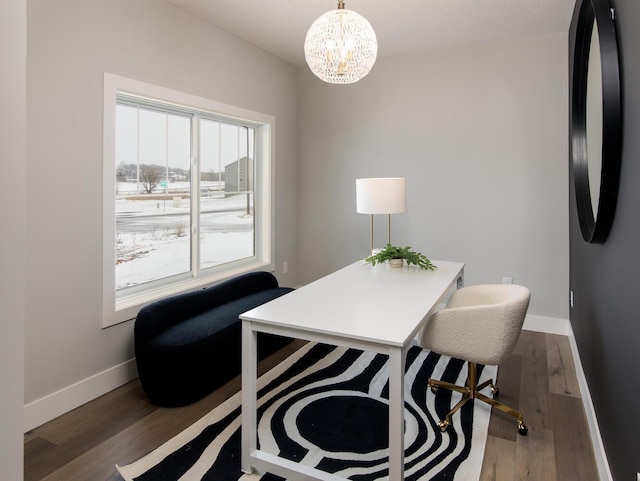 office with dark hardwood / wood-style flooring and a notable chandelier