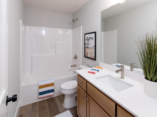 full bathroom featuring toilet, shower / bathing tub combination, a textured ceiling, vanity, and hardwood / wood-style floors