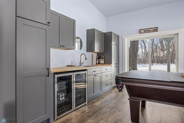 kitchen with gray cabinets, hardwood / wood-style flooring, sink, and beverage cooler