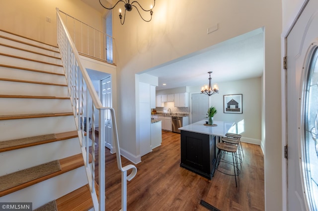 interior space with an inviting chandelier, a towering ceiling, and dark hardwood / wood-style floors