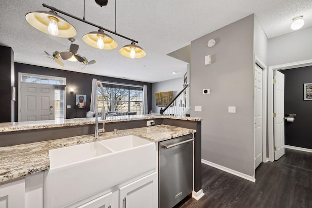 kitchen with decorative light fixtures, sink, white cabinets, stainless steel dishwasher, and light stone countertops