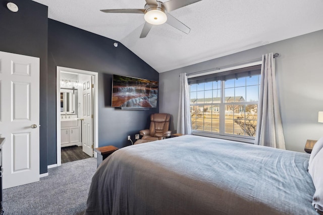 bedroom featuring ensuite bath, ceiling fan, dark colored carpet, a textured ceiling, and vaulted ceiling