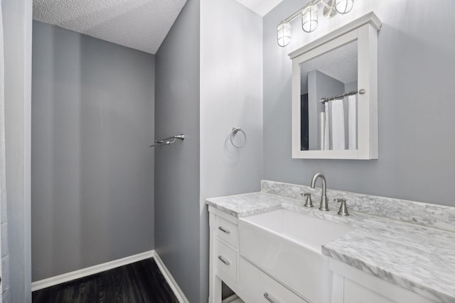 bathroom with vanity, hardwood / wood-style floors, and a textured ceiling