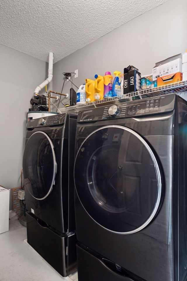 washroom featuring washing machine and clothes dryer and a textured ceiling