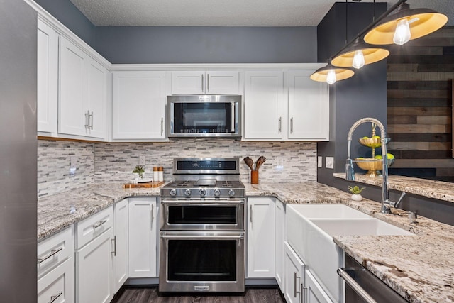 7316 Bunker Lake Blvd NW, Ramsey, MN 55303 - kitchen featuring stainless steel appliances, white cabinets, a sink, dark wood-type flooring, and a textured ceiling