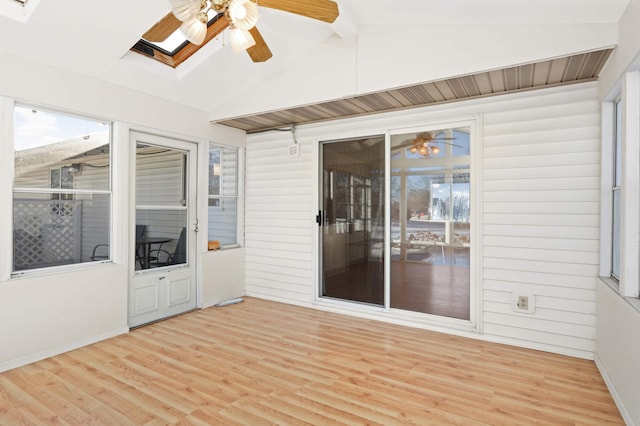 unfurnished sunroom with lofted ceiling with skylight and ceiling fan