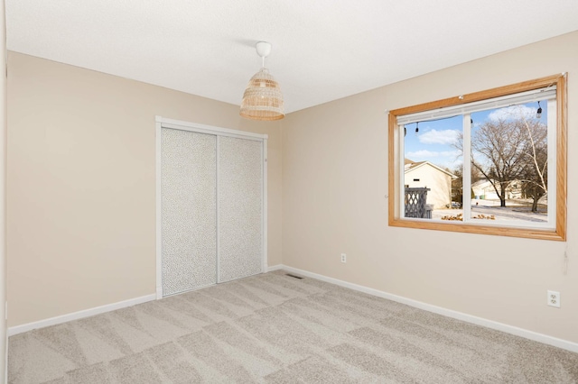 unfurnished bedroom with light carpet and a closet