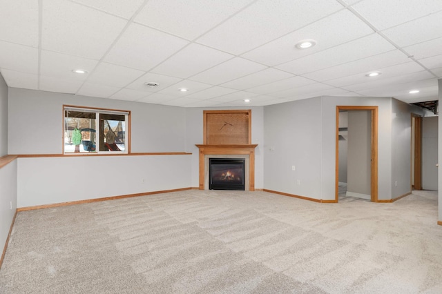 unfurnished living room with light colored carpet and a drop ceiling