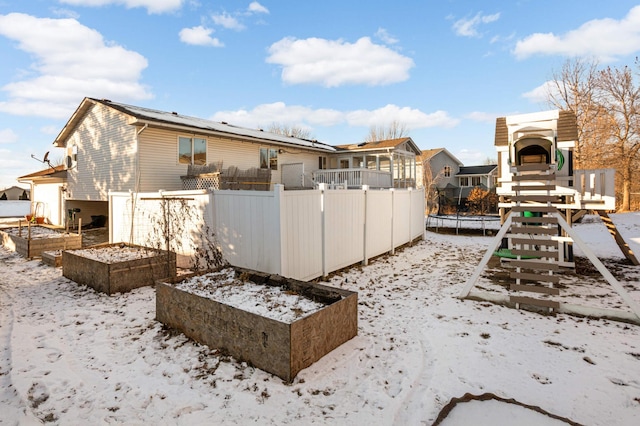 yard covered in snow with a playground and a trampoline