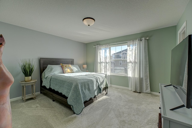 bedroom featuring light colored carpet and a textured ceiling