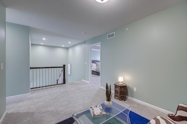 interior space featuring carpet flooring and a textured ceiling