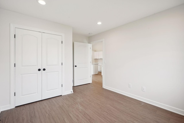 unfurnished bedroom featuring light hardwood / wood-style flooring and a closet