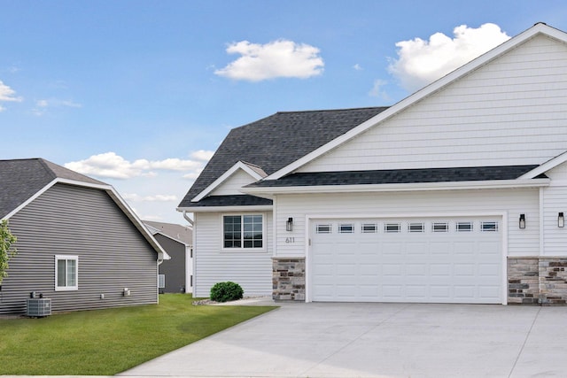 view of front of house with a garage, a front yard, and central AC unit