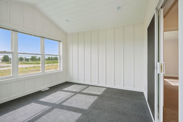 interior space with dark colored carpet and vaulted ceiling