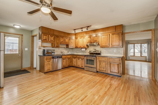 kitchen featuring sink, decorative backsplash, stainless steel appliances, and light wood-type flooring