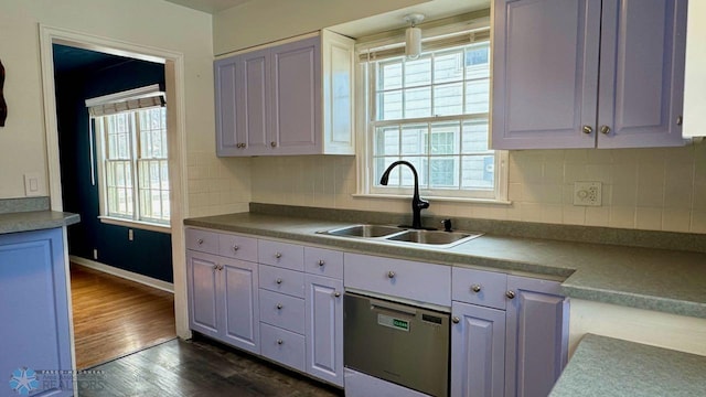 kitchen with tasteful backsplash, white cabinetry, dark hardwood / wood-style floors, and sink