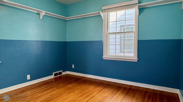 empty room with hardwood / wood-style flooring and lofted ceiling