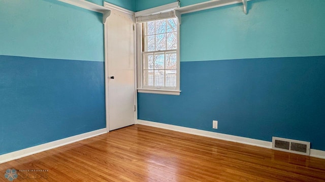 empty room featuring lofted ceiling and hardwood / wood-style floors