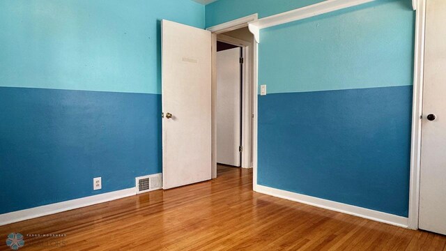 unfurnished room featuring hardwood / wood-style floors and vaulted ceiling