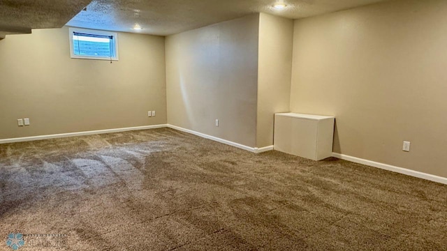 basement featuring carpet flooring and a textured ceiling