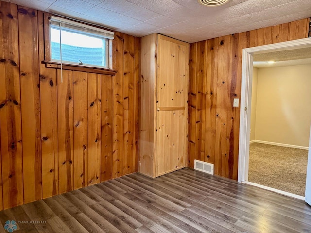 interior space with hardwood / wood-style flooring and wooden walls