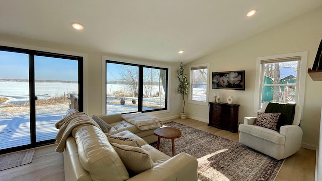 living room featuring a water view, lofted ceiling, and light hardwood / wood-style floors