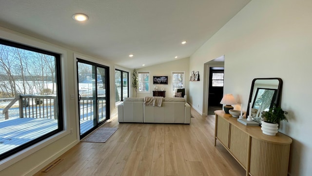 living room with light hardwood / wood-style floors and vaulted ceiling