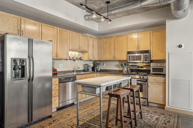 kitchen featuring stainless steel appliances, sink, light brown cabinets, and track lighting