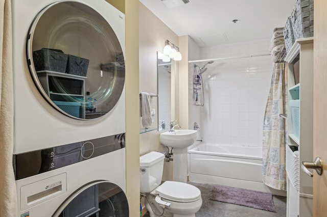 full bathroom featuring tiled shower / bath, stacked washer / drying machine, toilet, and sink