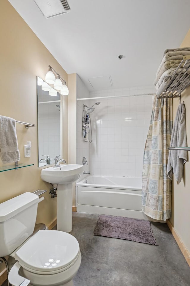 full bathroom with sink, concrete floors, shower / bath combo with shower curtain, and toilet