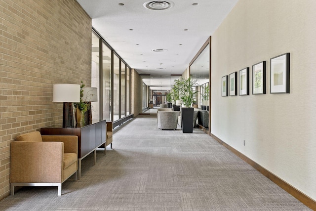 corridor with carpet floors and brick wall