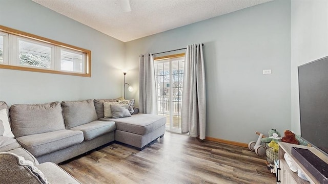 living area featuring baseboards, a textured ceiling, and wood finished floors