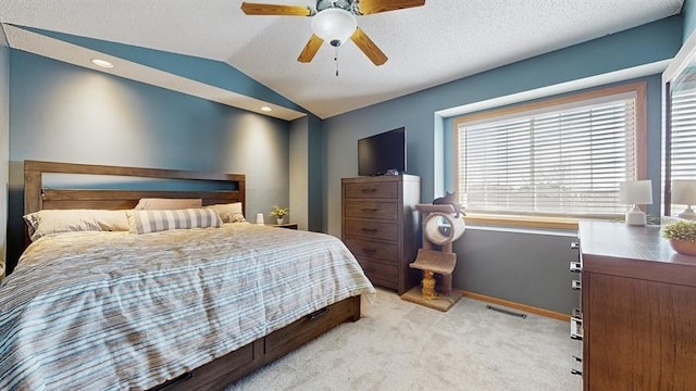 bedroom featuring a ceiling fan, visible vents, baseboards, lofted ceiling, and light colored carpet