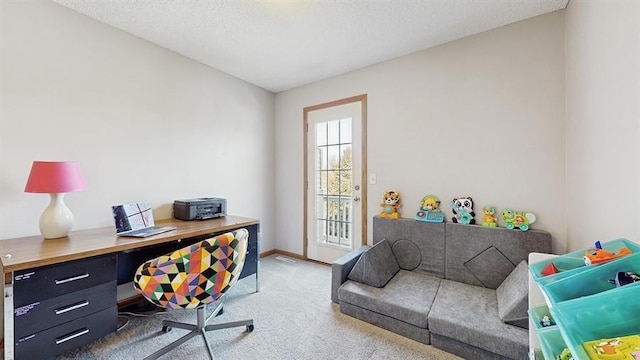 carpeted office space with baseboards and a textured ceiling