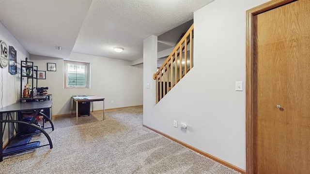 carpeted office featuring a textured ceiling and baseboards