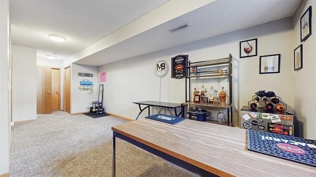 office area with carpet flooring, baseboards, visible vents, and a textured ceiling