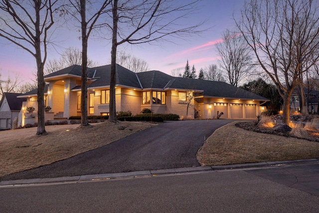 prairie-style house featuring aphalt driveway and an attached garage